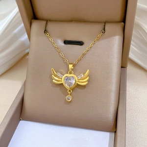 Detailed view of heart-shaped angel wings pendant with crystal on gold chain necklace
