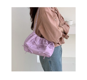 Detail of purple pleated cloud bag featuring three bows and woven chain strap