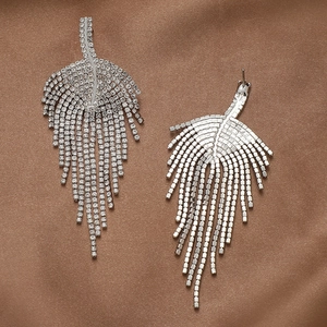 Detail of silver leaf tassel earrings with sparkling rhinestones on brown satin