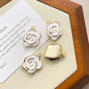Detail view of 14k gold-plated camellia flower pendant with white enamel finish