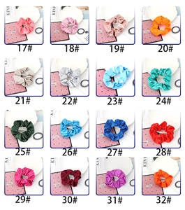 Detail view of colorful satin silk scrunchies in diverse numbered solid color options