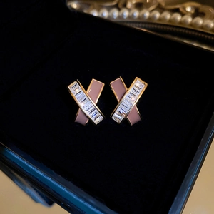 Detailed view of geometric gold-plated earrings with rectangular zircon and pink enamel