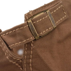 Detail view of cotton flat cap featuring adjustable bronze metal buckle and canvas texture