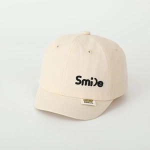 Detail der Smile-Stickerei und Markenetikett an beige Kinder-Baseballkappe