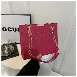 Detail of magenta tote bag featuring geometric quilted pattern and gold chain strap