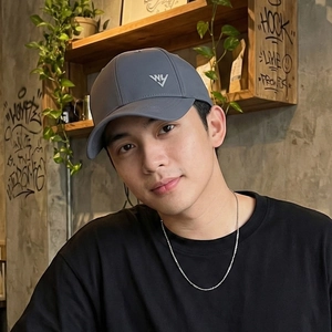 Deep grey quick-dry baseball cap with letter embroidery shown in a lifestyle indoor setting