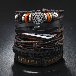 Macro shot of layered leather bracelet with silver metal charms and orange beads
