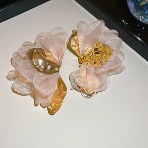 Detailed close-up of handmade pink chiffon fabric flower earrings with gold hammered metal