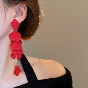 Close-up of red rose petal tassel earrings on model showing elegant matte finish details