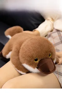 Close-up of plush platypus toy with soft brown fur and sparkling gold eyes details
