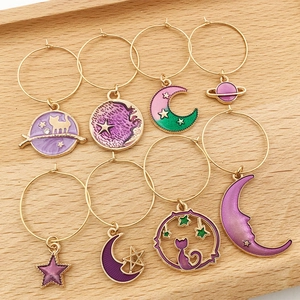 8-piece cat and star theme earring set with colorful enamel charms on wooden tray