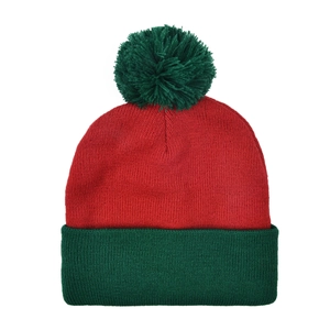 Close-up of red and green knitted Christmas hat with thick acrylic texture and green pompom