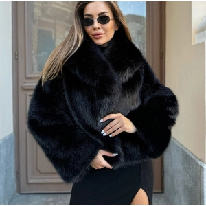 Détail d'un manteau en fausse fourrure noire montrant le revers épais et la texture