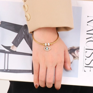 Detail of gold evil eye bracelet with sparkling crystals on a chic snake chain band