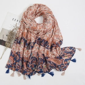 Detail of blue and orange floral paisley scarf with tassels and sheer muslin fabric