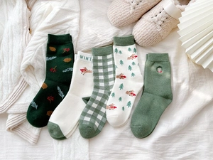 Detailed flat lay of five winter cotton blend Christmas socks with elk and tree embroidery