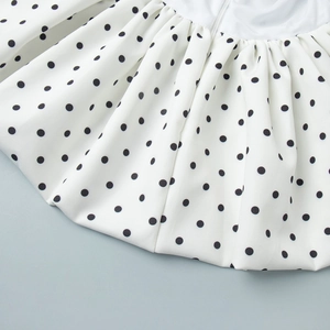 Détail d'un pantalon large à pois avec tissu plissé et fermeture éclair invisible