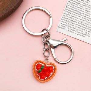 Detailed top view of orange heart-shaped fruit tart resin charm on silver keychain