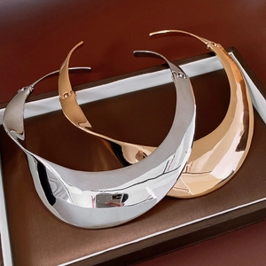 Detailed close-up of chunky twisted metal collars in polished gold and silver finishes