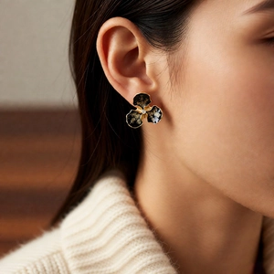 Vue détaillée d'un clou d'oreille floral vintage en émail noir avec un diamant central