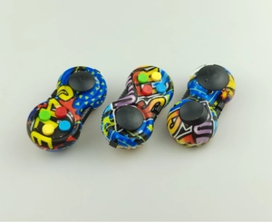 Close-up of three colorful graffiti-style fidget pads with joysticks and tactile buttons