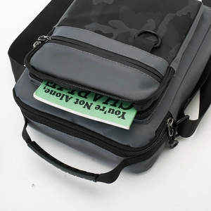 Detail showing high-capacity pockets with a camouflage pattern and anti-slip rubber handle