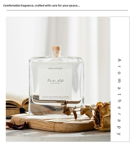 Detail of square glass aromatherapy bottle with wood cork on a rustic wooden tray