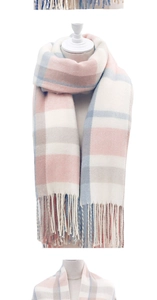 Detail of pink and blue plaid scarf showing soft tassel edges and warm woven texture