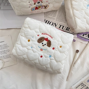 Close-up of heart-quilted puppy embroidery makeup bag with soft fabric and purple zipper