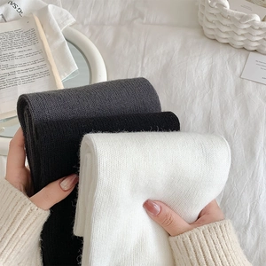 Detail of thick ribbed knit texture on thermal over-the-knee socks in neutral colors