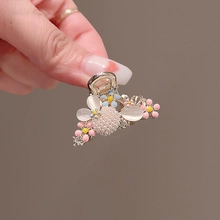 Detail view of flower hair claw clip with cat eye stones and colorful floral accents