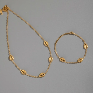 Flat lay of gold plated stainless steel necklace and bracelet set with shell pendants