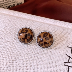 Gros plan de boucles d'oreilles rondes rétro imprimé léopard avec bordure perlée argentée