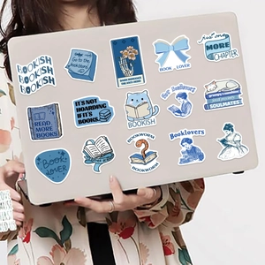 Blue bookish themed stickers applied to a laptop lid shown held by a hand