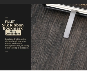 Detail view of a premium grey silk ribbon bookmark on a black embossed hardcover notebook