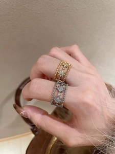 Detail shot of hollow starburst rings with cubic zirconia inlay on model's fingers
