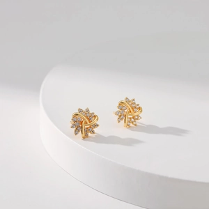 Elegant 18K gold brass snowflake earrings with micro-set white zircon on a white stand