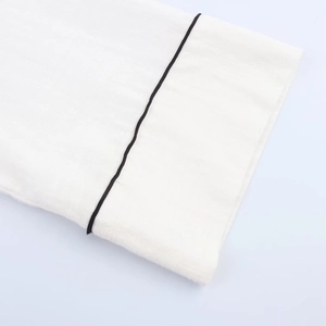 Macro detail of high-quality white linen fabric with black contrast stitching edge