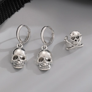 Detailed view of silver gothic skull earring set featuring spider and skeleton hand design