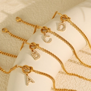 Elegante goldene Buchstaben-Armbänder A B C D mit Zirkonia auf weißem Aufsteller