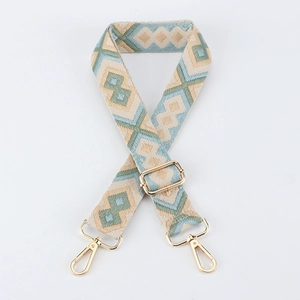 Detail of adjustable geometric woven bag strap with golden metal lobster clasps