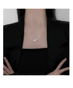Detail of s925 sterling silver necklace with a natural baroque pearl on a female model