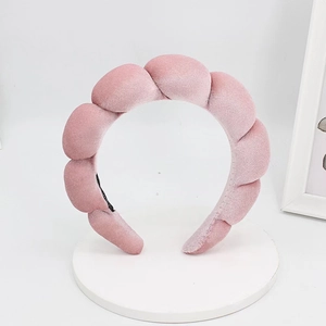 Macro detail of a pink velvet braided headband with soft texture and puffy cloud design