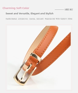 Detail of bright orange PU leather skinny belt with golden alloy buckle for women