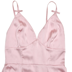 Detailed close-up of pink satin V-neck dress with spaghetti straps and small bow accents