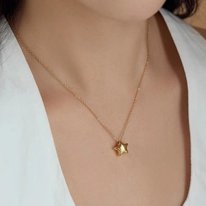 Collier minimaliste avec pendentif étoile dorée pour femme porté comme chaîne de clavicule