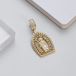 Close-up of 14K gold plated Virgin Mary pendant with colorful zircon stones on gray surface