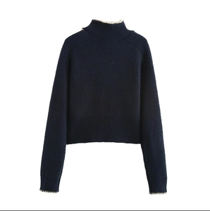 Pull en maille côtelée bleu marine avec bords ondulés blancs au col et poignets
