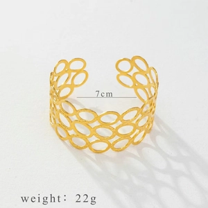 Detailed view of gold open cuff bracelet with hollow circle links and hammered texture