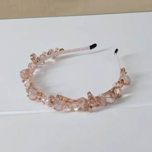 Close-up of pink crystal beads and satin-wrapped details on a handcrafted headband